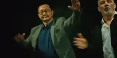 Asian man dancing with raised hand
