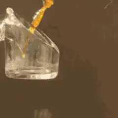 Orange liquid pouring into glass