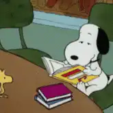 Snoopy reading a book and laughing