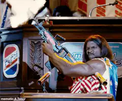 Ice-T firing a gun at a podium