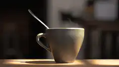 Steaming coffee cup with spoon