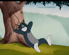 Tom leaning against a tree laughing