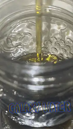 Golden liquid poured into glass jar