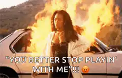 Woman standing in front of burning car