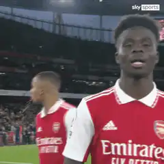 Bukayo Saka smiling on the pitch