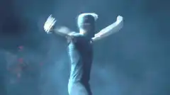 Man dancing on stage with arms out