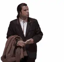 John Travolta holding coat looking around