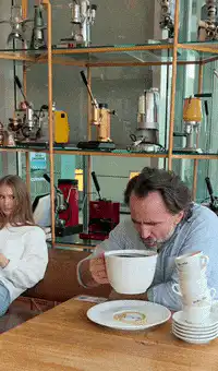 man drinks coffee from large cup