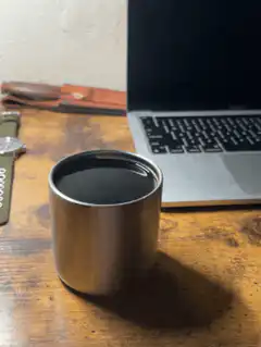 Coffee cup on desk next to laptop