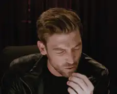 Man in leather jacket eating and reacting