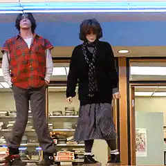 Two people standing on chairs in a store