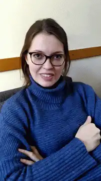 woman in blue sweater gives thumbs up