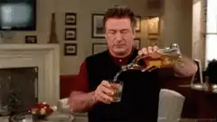Alec Baldwin pouring a drink