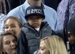 Baby takes off hat at basketball game