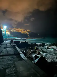 nighttime ocean waves crashing on rocks