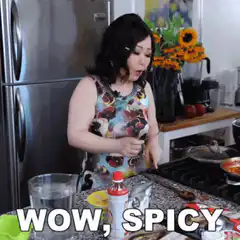 Woman reacts to spicy food in kitchen