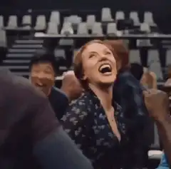 Woman laughing and clapping in audience