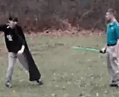 Man in cape sliced by green lightsaber
