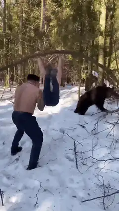 man lifts friend onto branch to escape bear