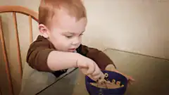 Toddler eating cereal with intense focus