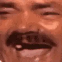 Man with mustache squinting then opening eyes