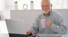 Happy senior man with laptop and mug