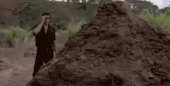 Man standing next to a big pile of shit
