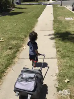 Toddler pulling a rolling suitcase