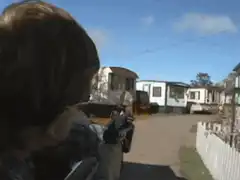 Boy aiming rifle at trailer park