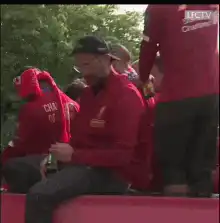 Man in red jacket gives thumbs up