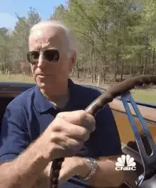 Joe Biden driving a car and smiling