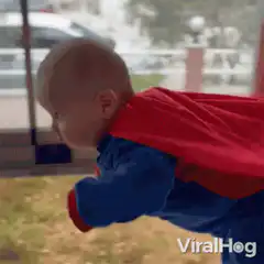 Baby dressed as Superman flying