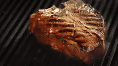 Steak sizzling on a grill