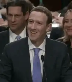 Mark Zuckerberg smiling at hearing