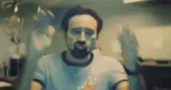 man waving hands in front of camera