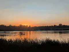 sunset over river with canoe