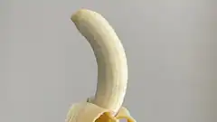 peeled banana against gray background