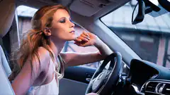 woman driving car looking thoughtful