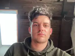 Man with messy hair in green hoodie