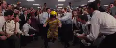 Office workers cheer as a man in a yellow helmet is lifted