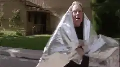 Man in emergency blanket throws beer