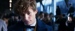 Eddie Redmayne looks up with a smirk