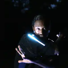 Man holding glowing light stick in dark