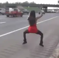 Woman dancing on highway shoulder
