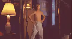shirtless boy dancing in bedroom