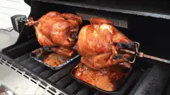Two chickens rotisserie on grill