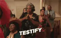 Older woman raising hands and saying testify