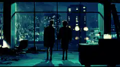 Two people holding hands looking at city lights
