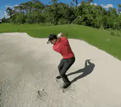 golfer hits ball out of sand trap