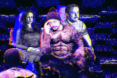 Three people sitting in a blue lit room